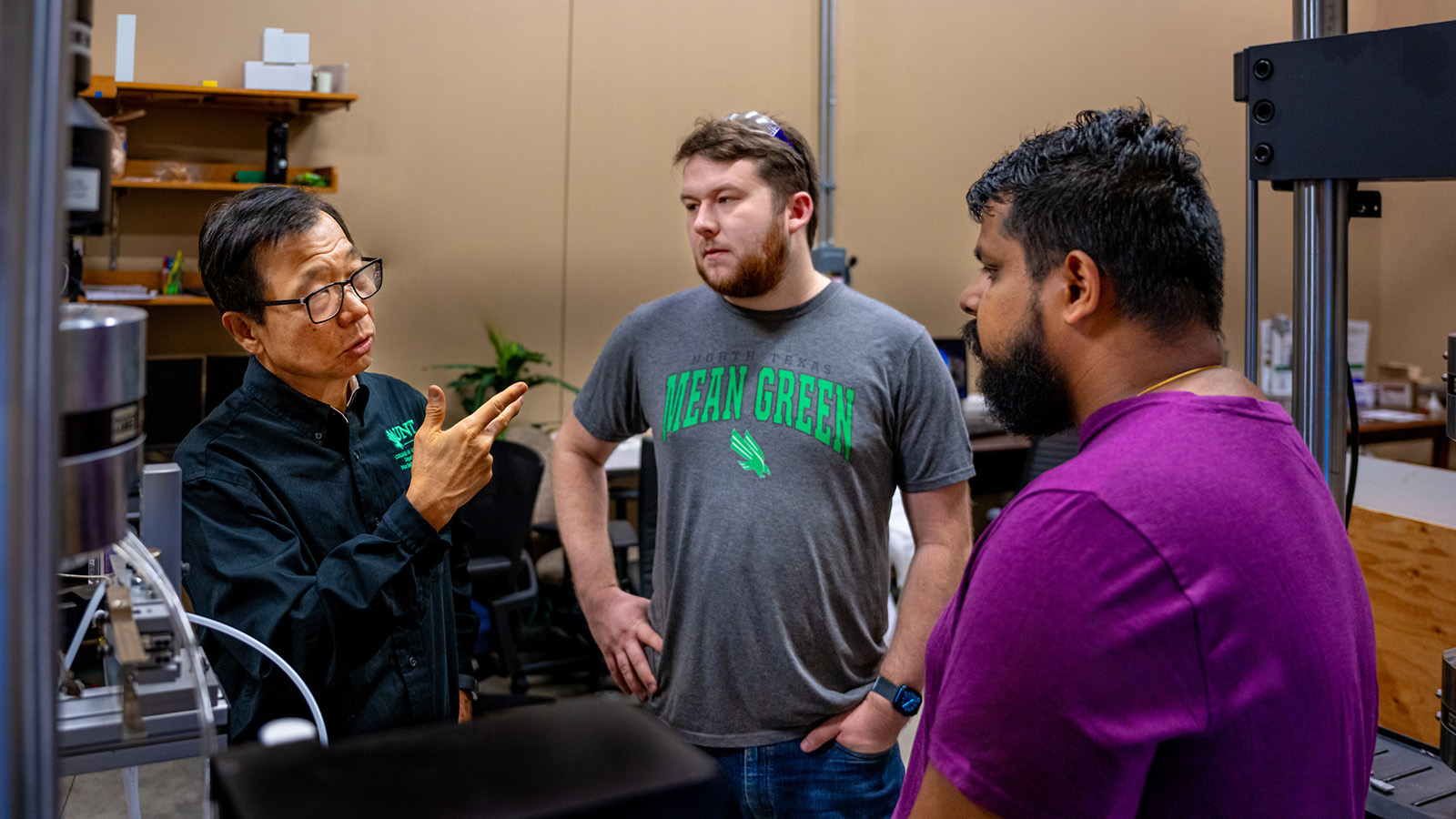 Two students with a faculty member in a UNT mechanical and energy engineering lab.
