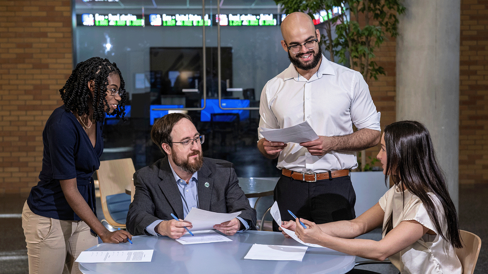 A group of UNT Financial Planning MBA students gather in the UNT business building.