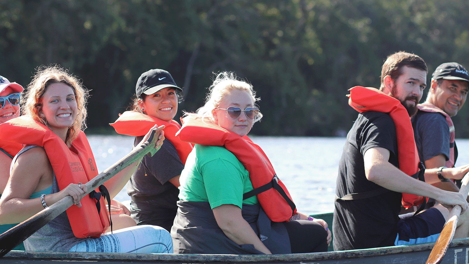 A group of young people wearing life vests in a kayak