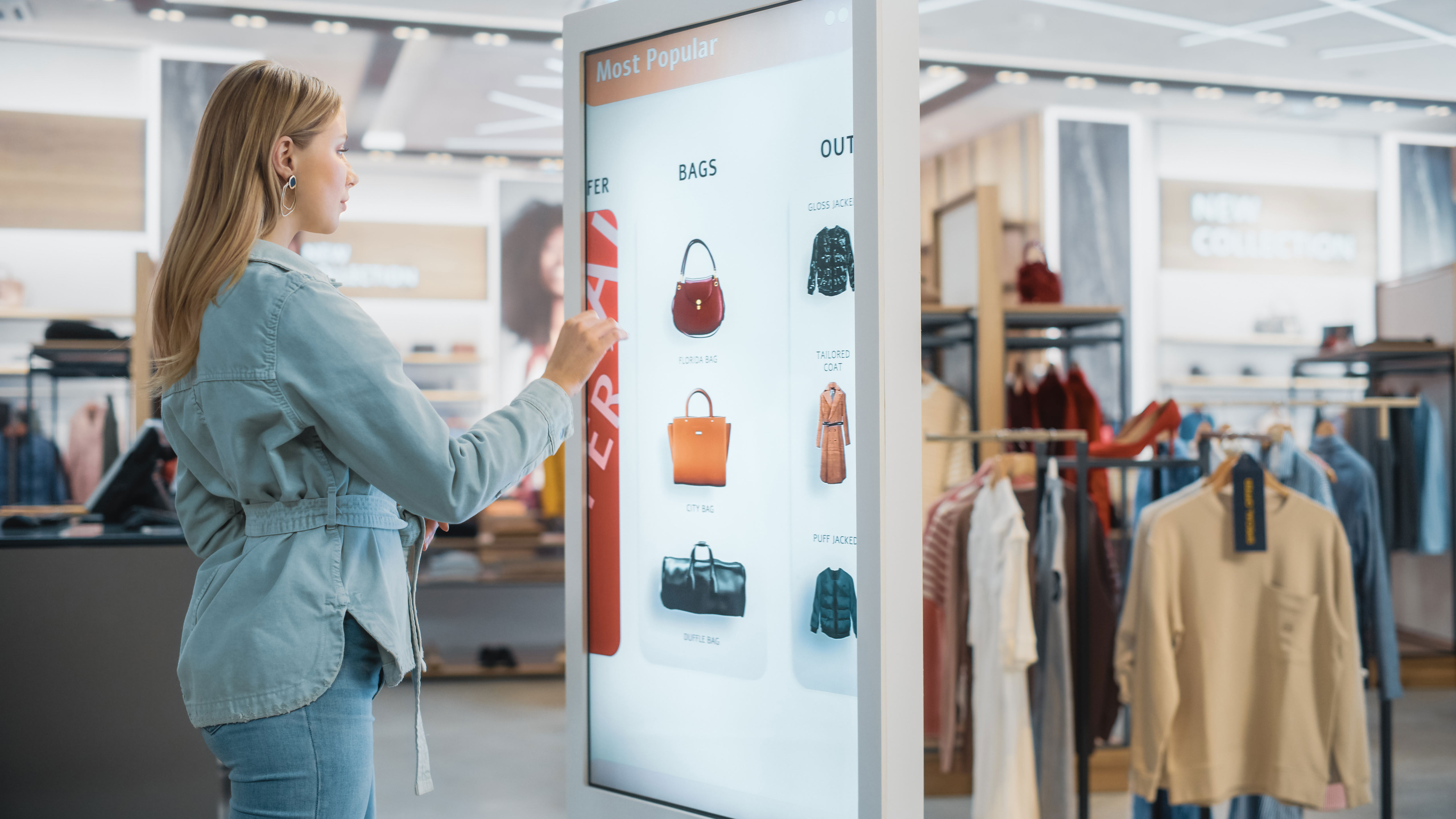 A woman views products on a screen at a clothing retailer