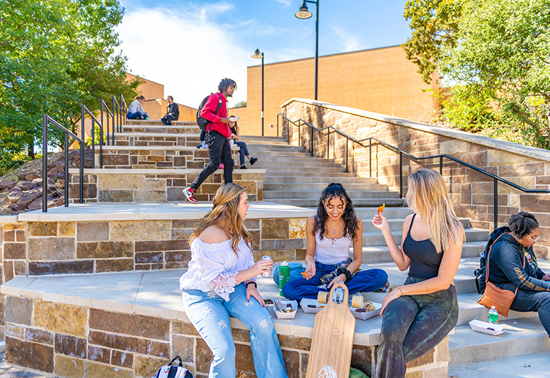 Students having lunch outside on the campus stairs