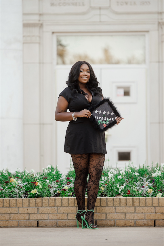 Mya Vance poses with her grad cap on UNT's campus